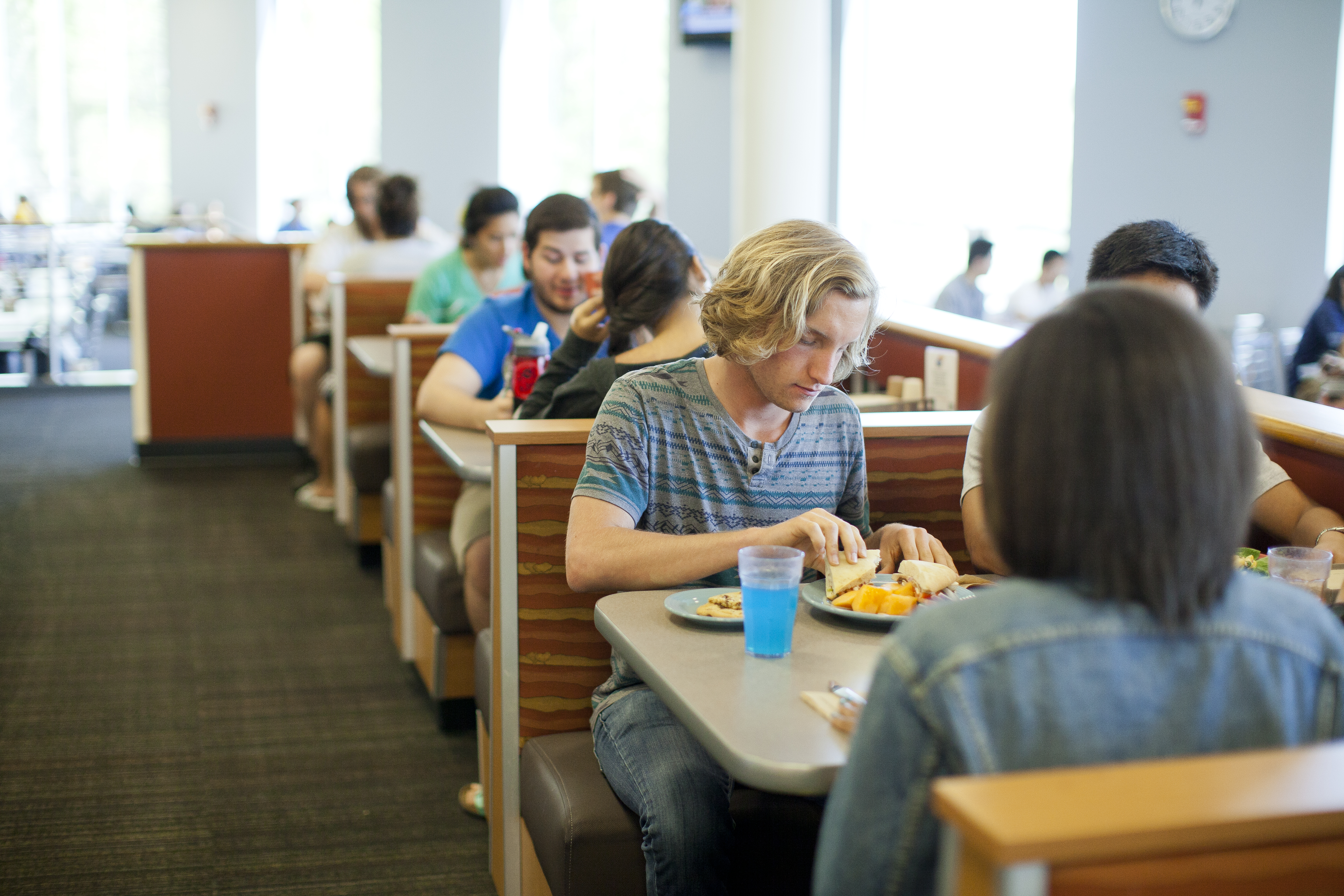 Students eat at booths in the dining hall