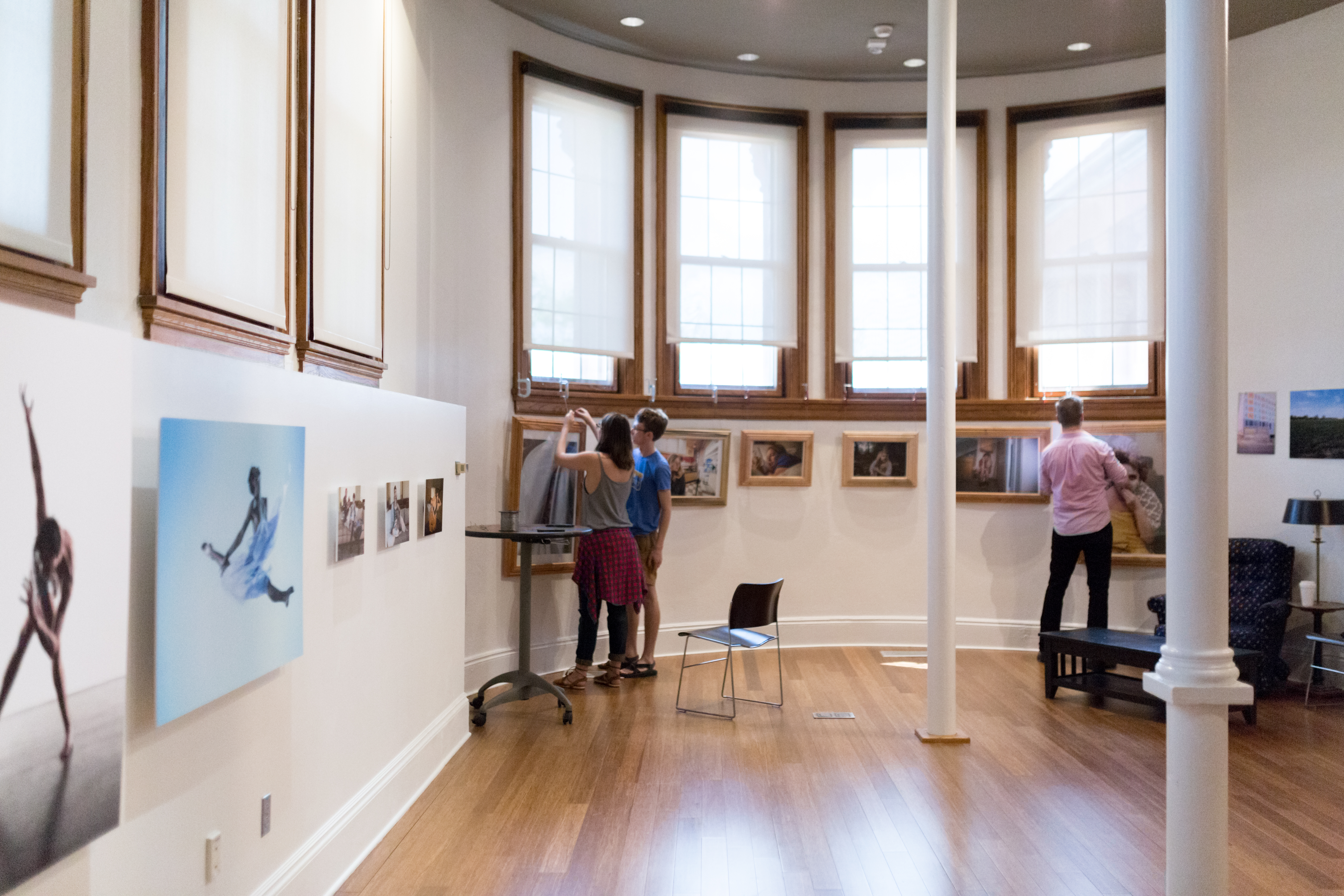 Students mount an exhibit of photographs in the Commons area  
