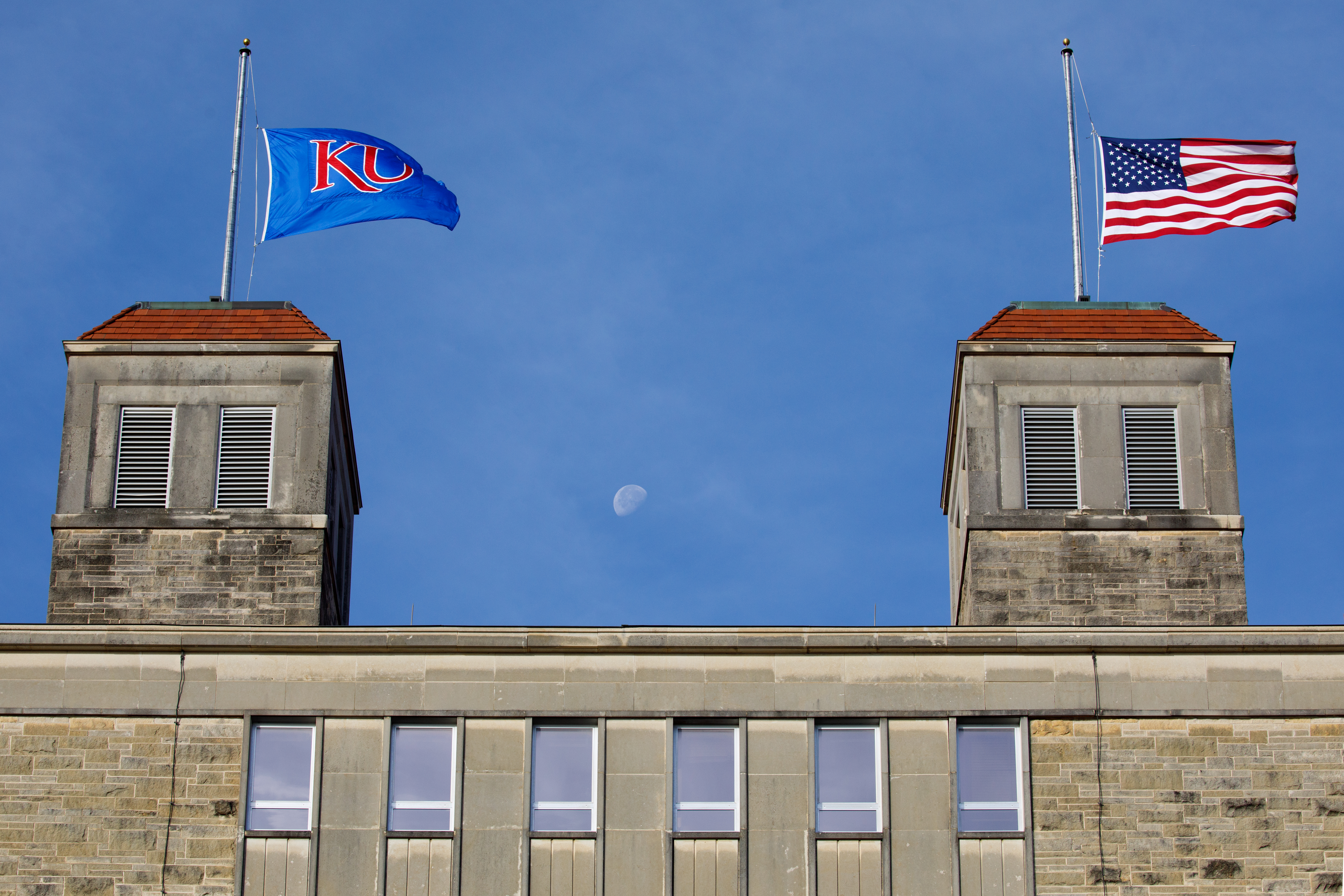 The American flag and KU flag fly atop the cupolas of Fraser Hall