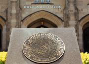 A reproduction of the University Seal sits in a bed of tulip