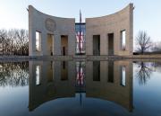 The entrance to the Dole Institute of Politics reflects in the still surface of a pool at the front of the building