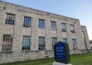 Limestone-faced building with blue sign out front that reads Military Science