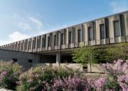 An exterior photograph of Wescoe Hall, with lilacs blooming in front
