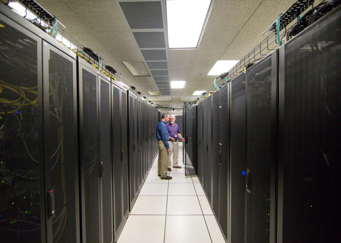 Two IT staff members in a data center hallway