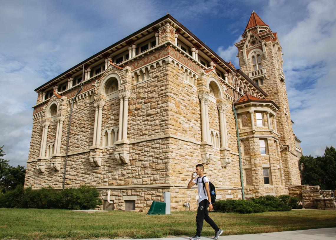 The limestone exterior of Dyche Hall is lit brightly by the midday sun