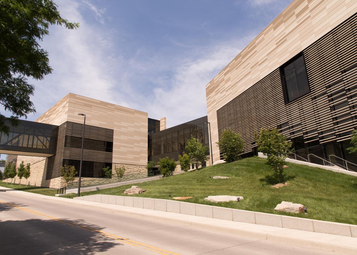 The two towers of the Earth, Energy & Environment Center connect at their base by a hallway of dark-tinted glass