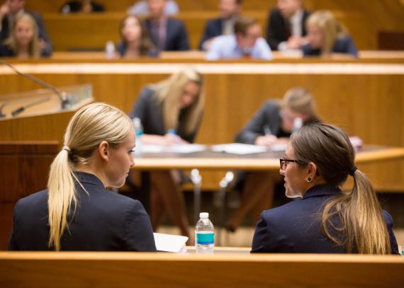 Students converse in a law classroom
