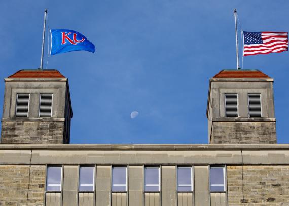 The American flag and KU flag fly atop the cupolas of Fraser Hall