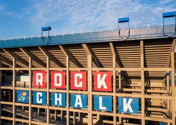 the east side of David Booth Kansas Memorial Stadium is decorated with the chant “Rock Chalk.”