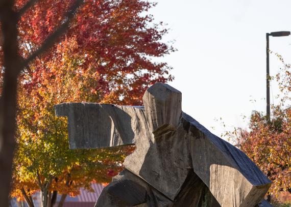 A tree shows its fall colors behind the statue