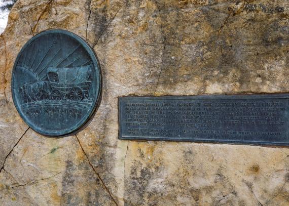 A close-up of the bronze medallion and plaque on the Oregon Trail Marker