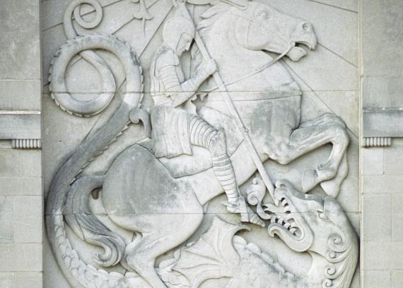 A close-up of a limestone relief of Saint George slaying a dragon 